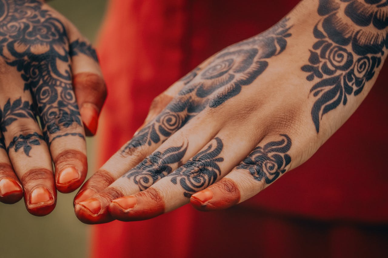 About Us Close-up of hands adorned with intricate henna designs, showcasing traditional artistry.